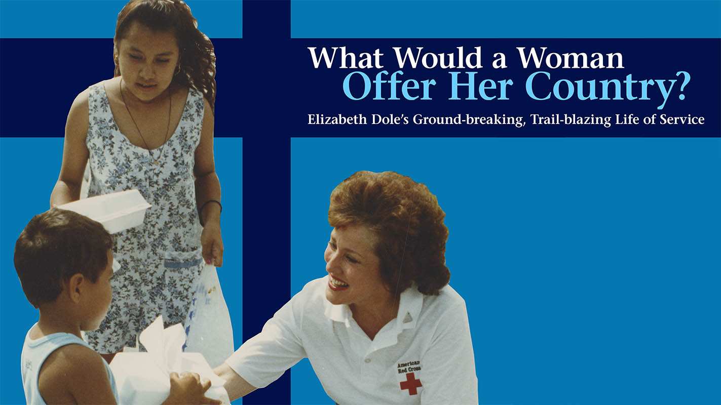 exhibit banner with cut-out images from a photograph. Elizabeth Dole is kneeling and handing a food parcel to a child. Behind the boy stands another woman holding another food container. Elizabeth Dole is wearing an American Red Cross shirt. The Exhibit Title text reads 'What Would a Woman Offer Her Country? Elizabeth Dole's Ground breaking, trail blazing life of service.'